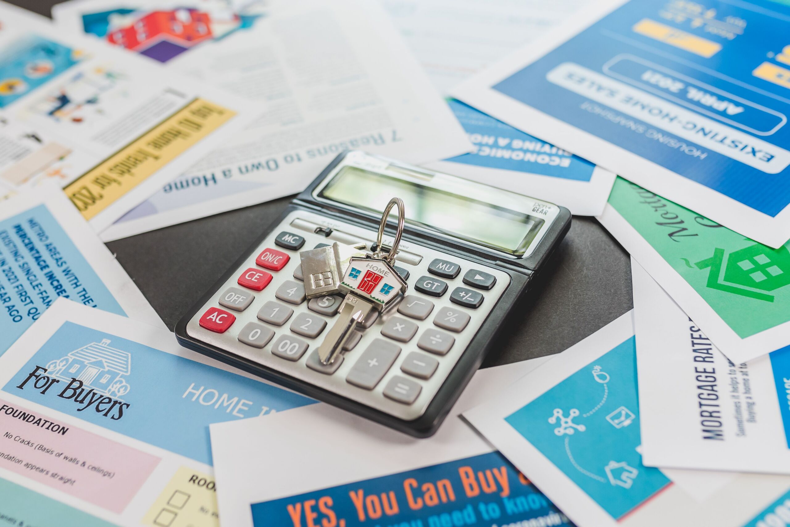 a calculator surrounded by paper on a table