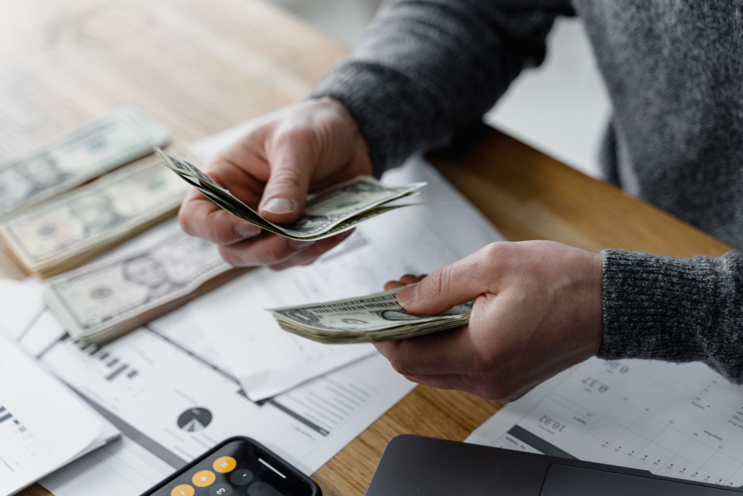 a person counting money at a table
