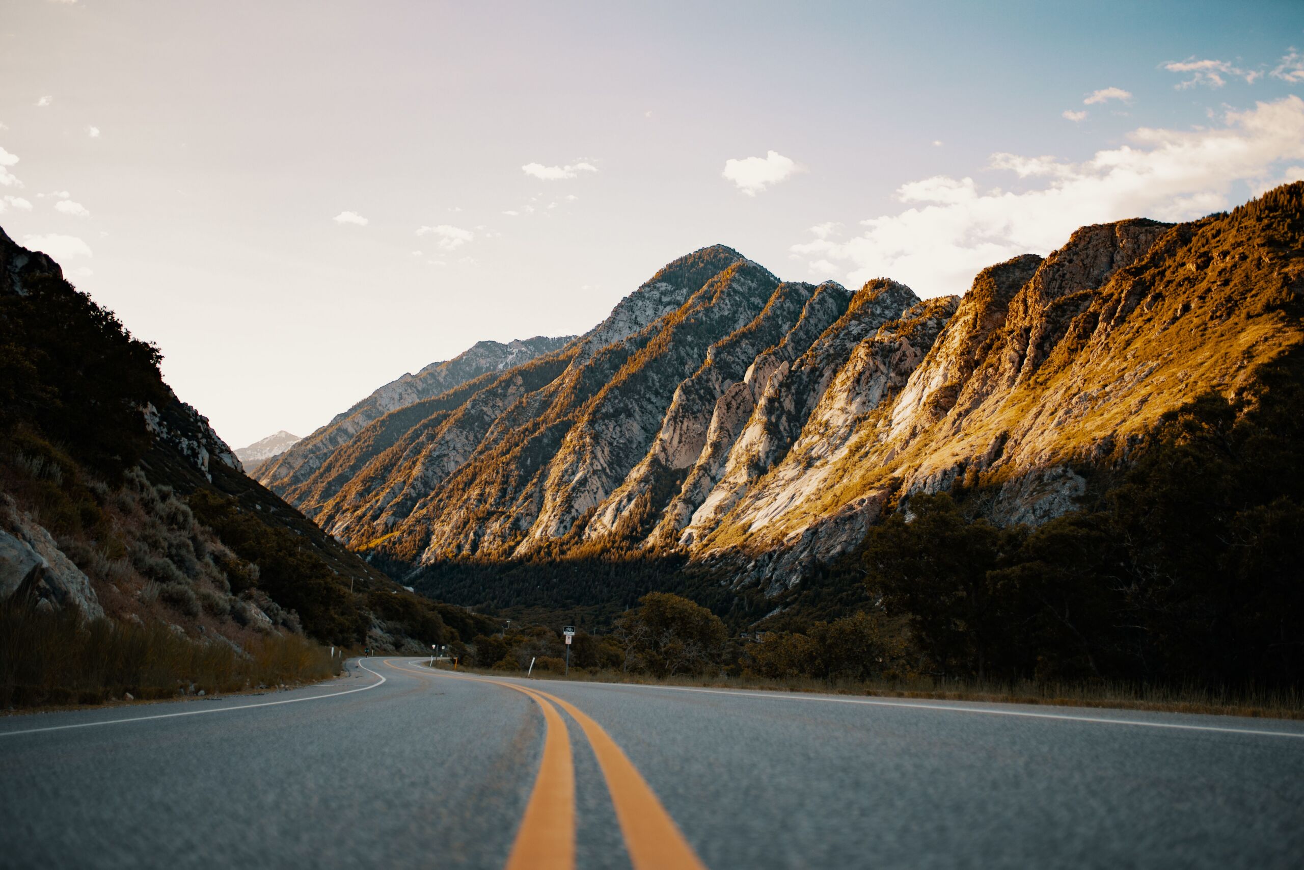 a landscape photo of winding road and a mountain