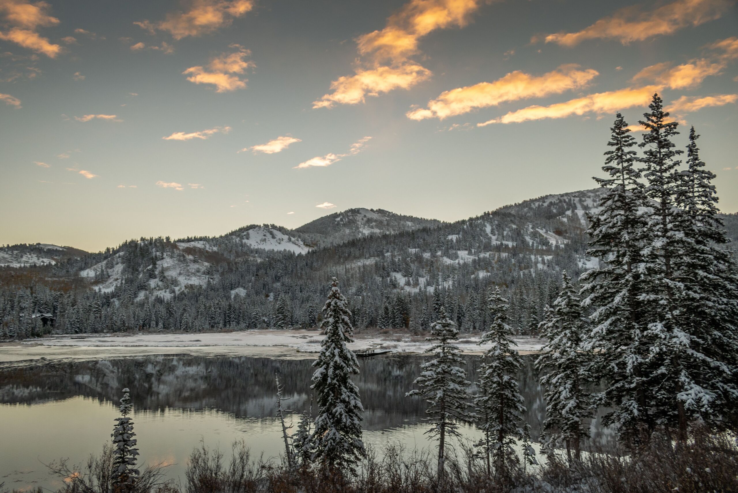 scenic view of lake near a snowy mountain